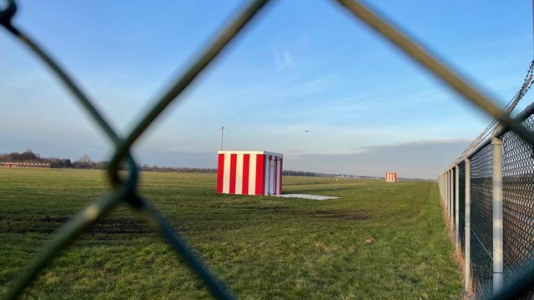 Rood / Wit huisje op een groen grasveld 