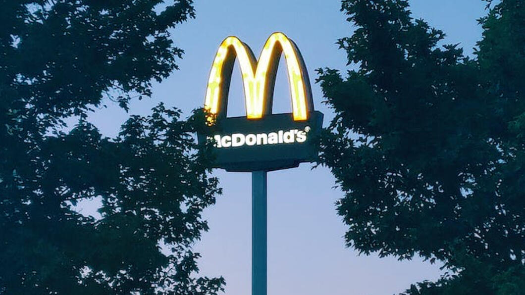 Reclamezuil van McDonald's met enkele bomen ervoor