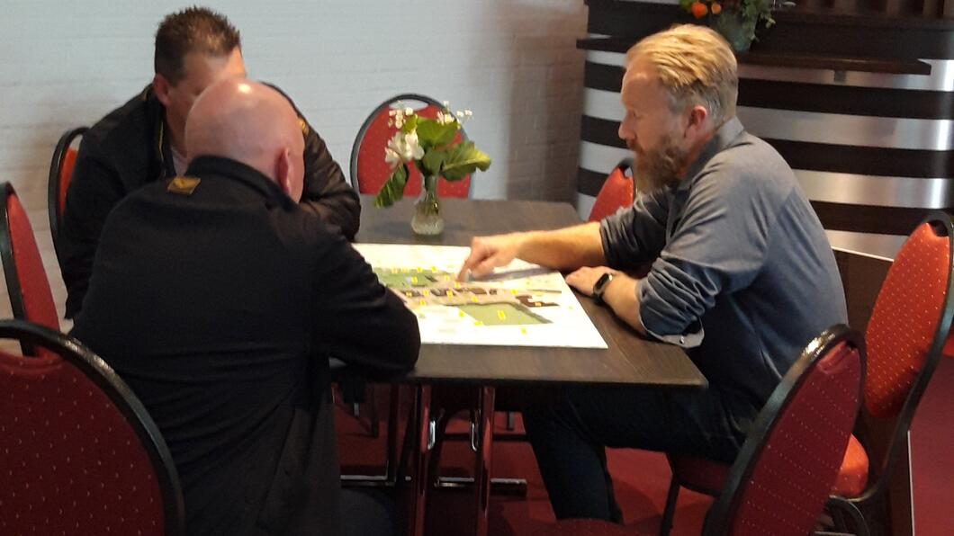 Enkele mensen aan een tafel bij de inloop voor centrum Eelde