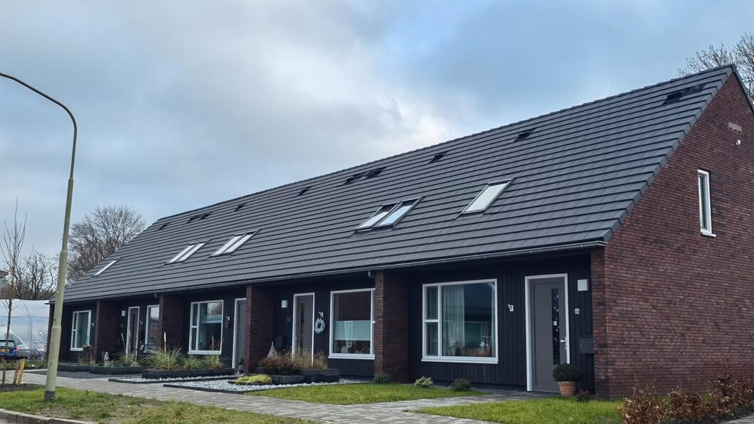 Een rijtjeshuis in Vries. Met een lantaarnpaal en wat groen voor het huis