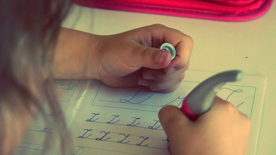 Onderwijs / Leren; een kind leert om met een aangepaste pen te schrijven
