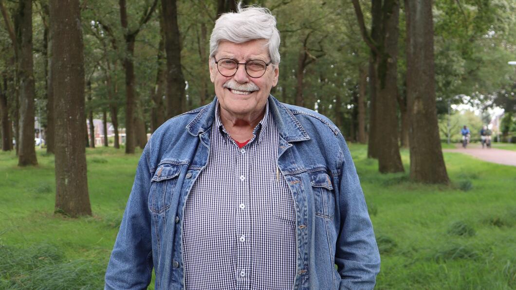 Fractielid Willem van der Meij draagt een blauw jasje en een blauwe blouse. Hij staat voor enkele bomen en op gras