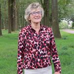 Fractielid Maya Vermeulen draagt een paars / rood blousje en staat voor enkele bomen op een grasveldje