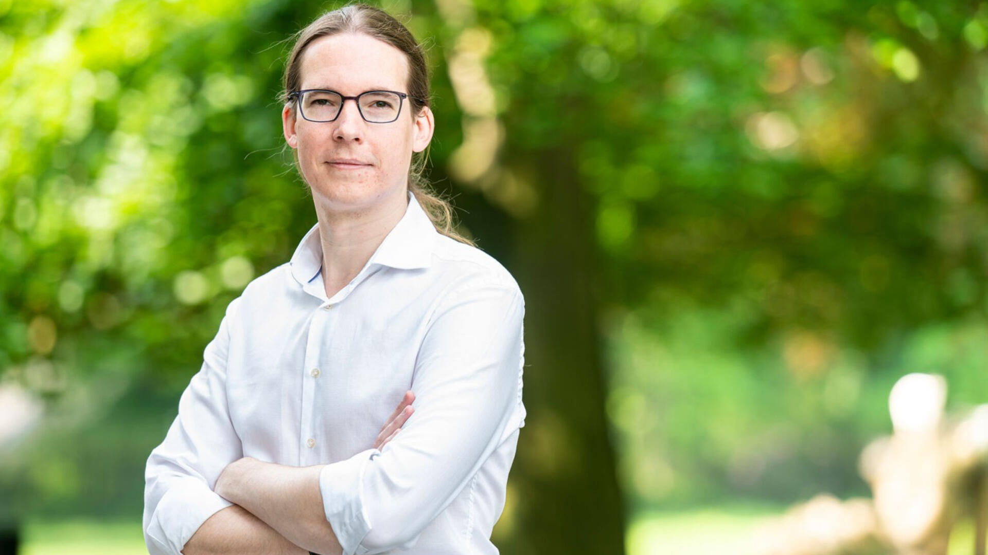 Hans Kuipers, onze nieuwe wethouder. Hans heeft een witte blouse aan en op de achtergrond zijn wat bomen te zien