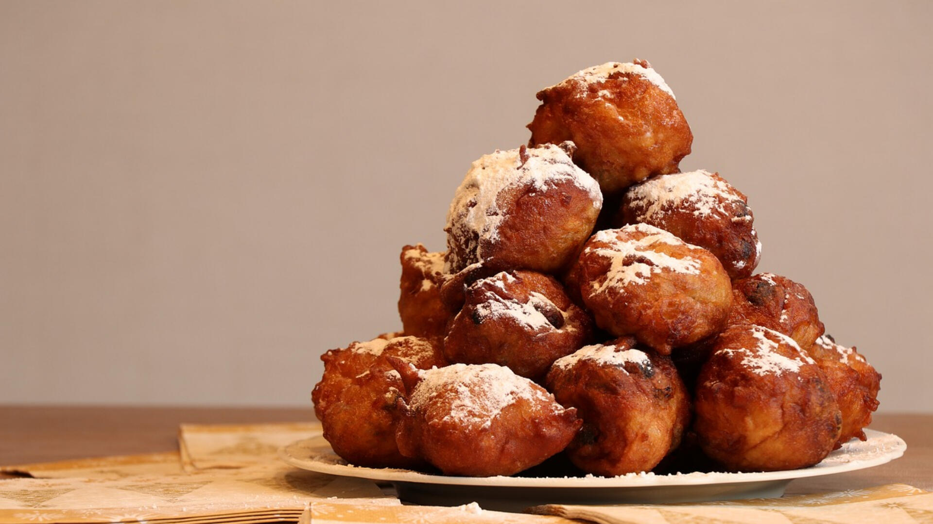 Oliebollen met poedersuiker, op een bord