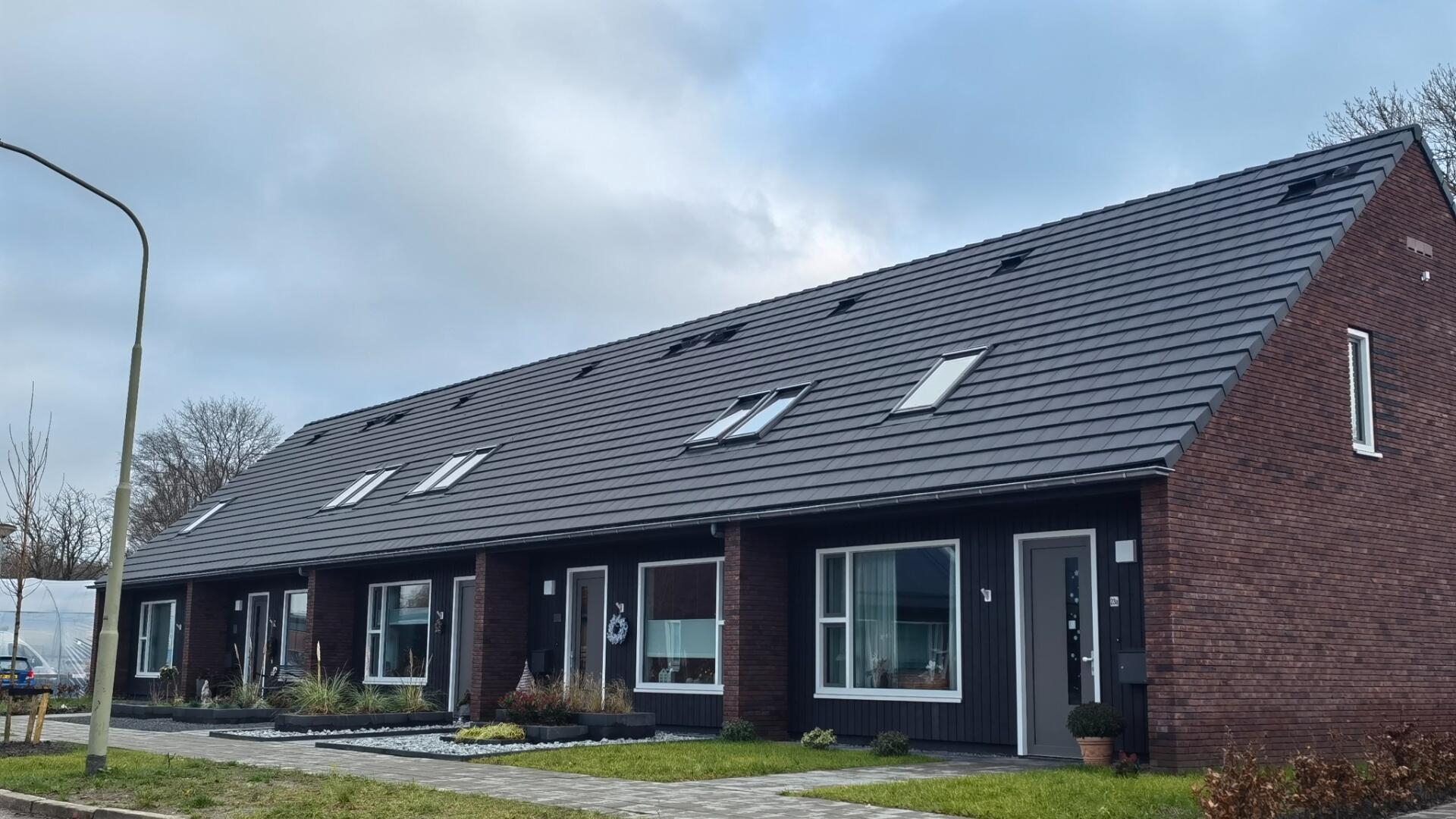 Een rijtjeshuis in Vries. Met een lantaarnpaal en wat groen voor het huis